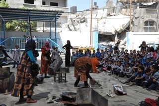 Open-air school performance by Theatre Day Productions among destroyed buildings, September 2014