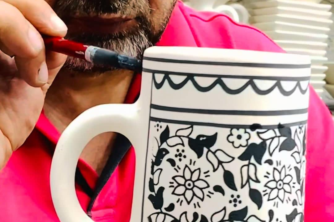 A craftsman painting a pottery jug from Hebron